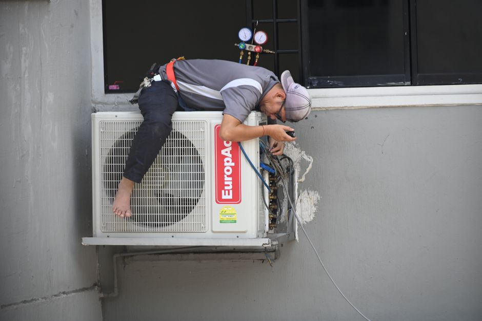 HVAC technician repairing a residential air conditioning unit